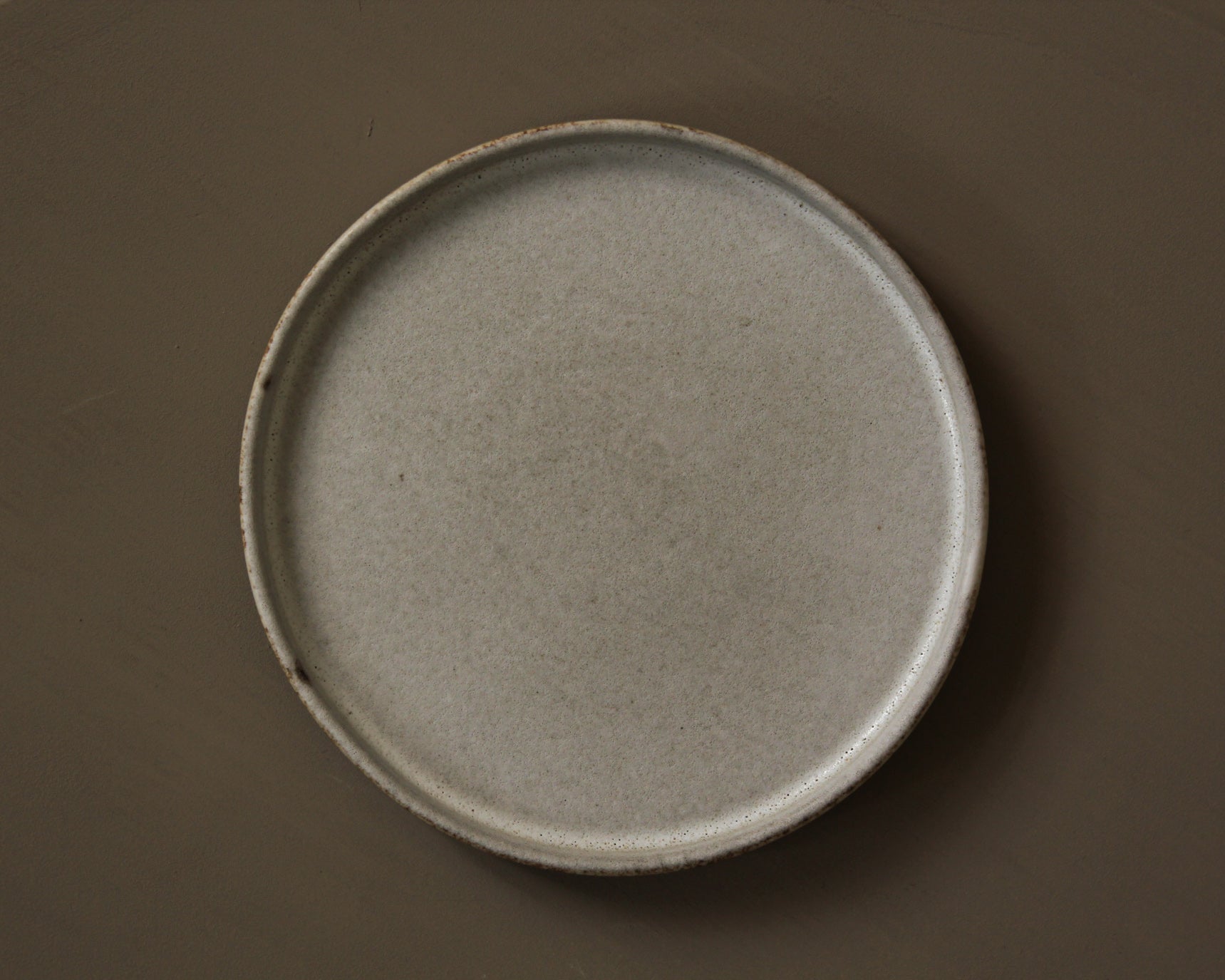 Round ceramic plate on a brown background