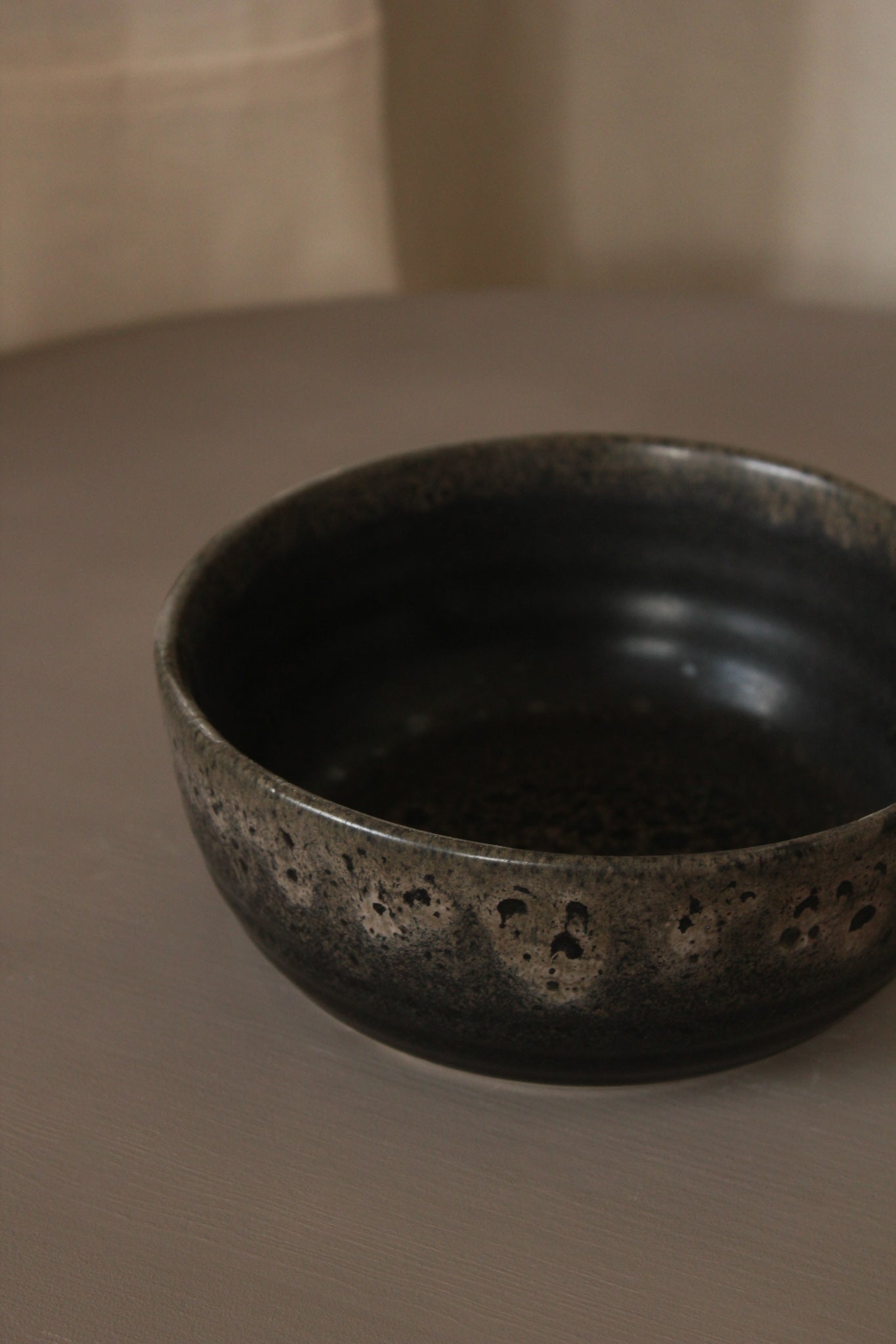 Black ceramic bowl on a brown surface